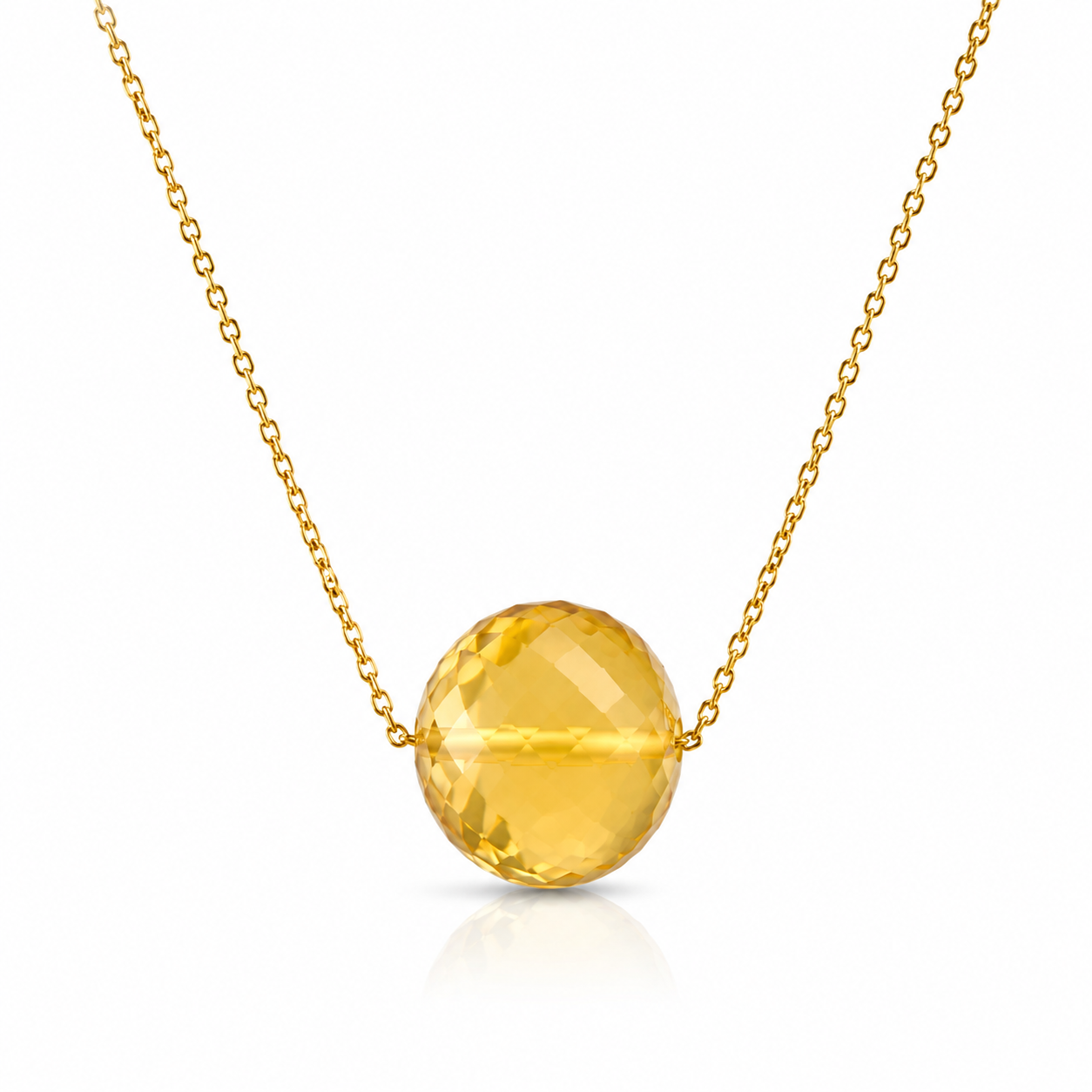 Gold necklace with a large yellow gemstone on a white background